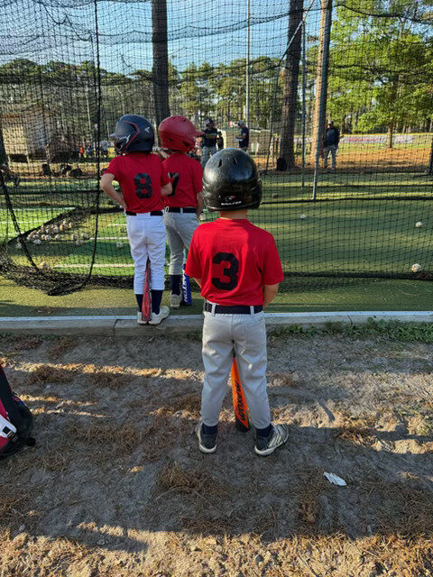 Young baseball players waiting to bat