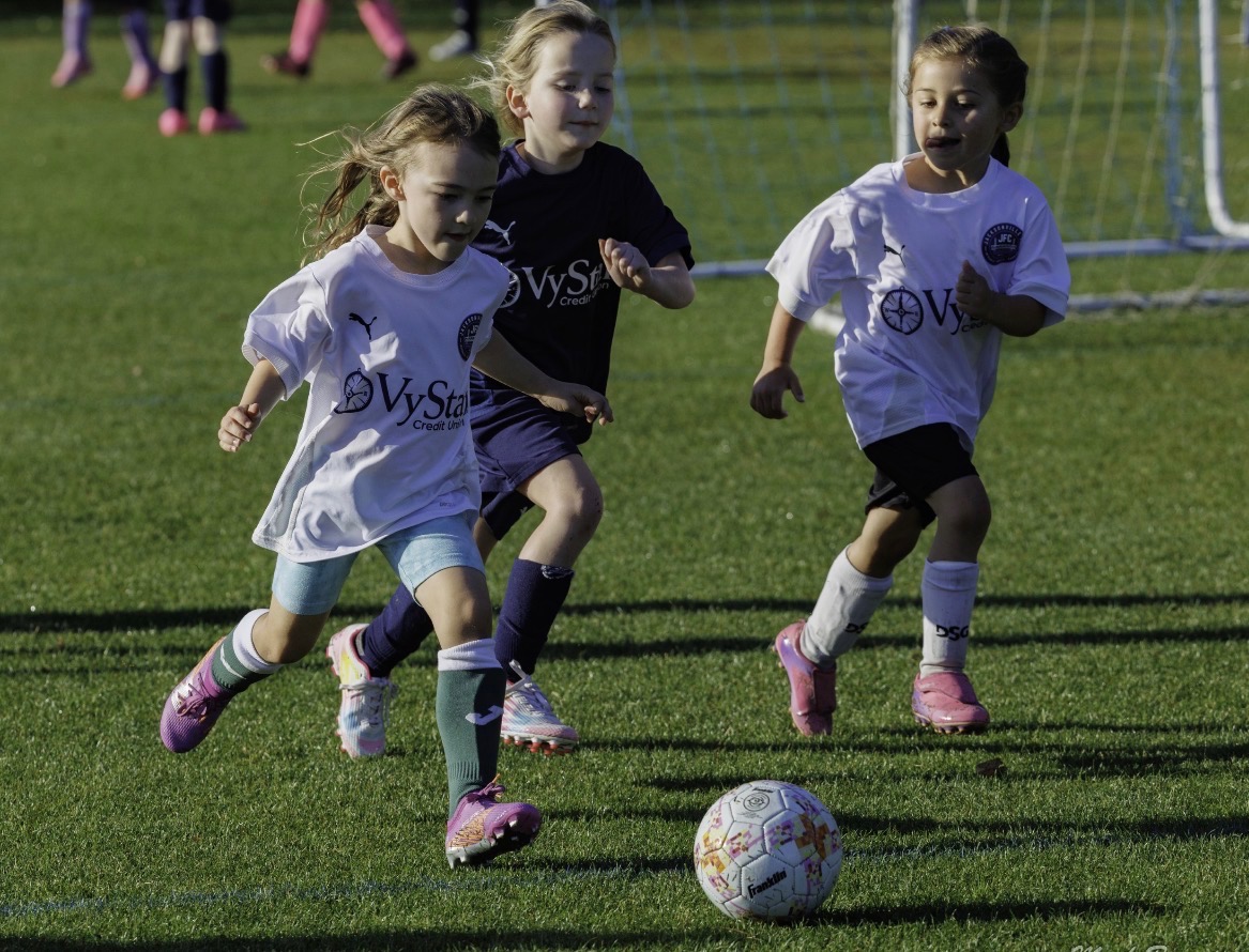 Youth soccer players heading for goal